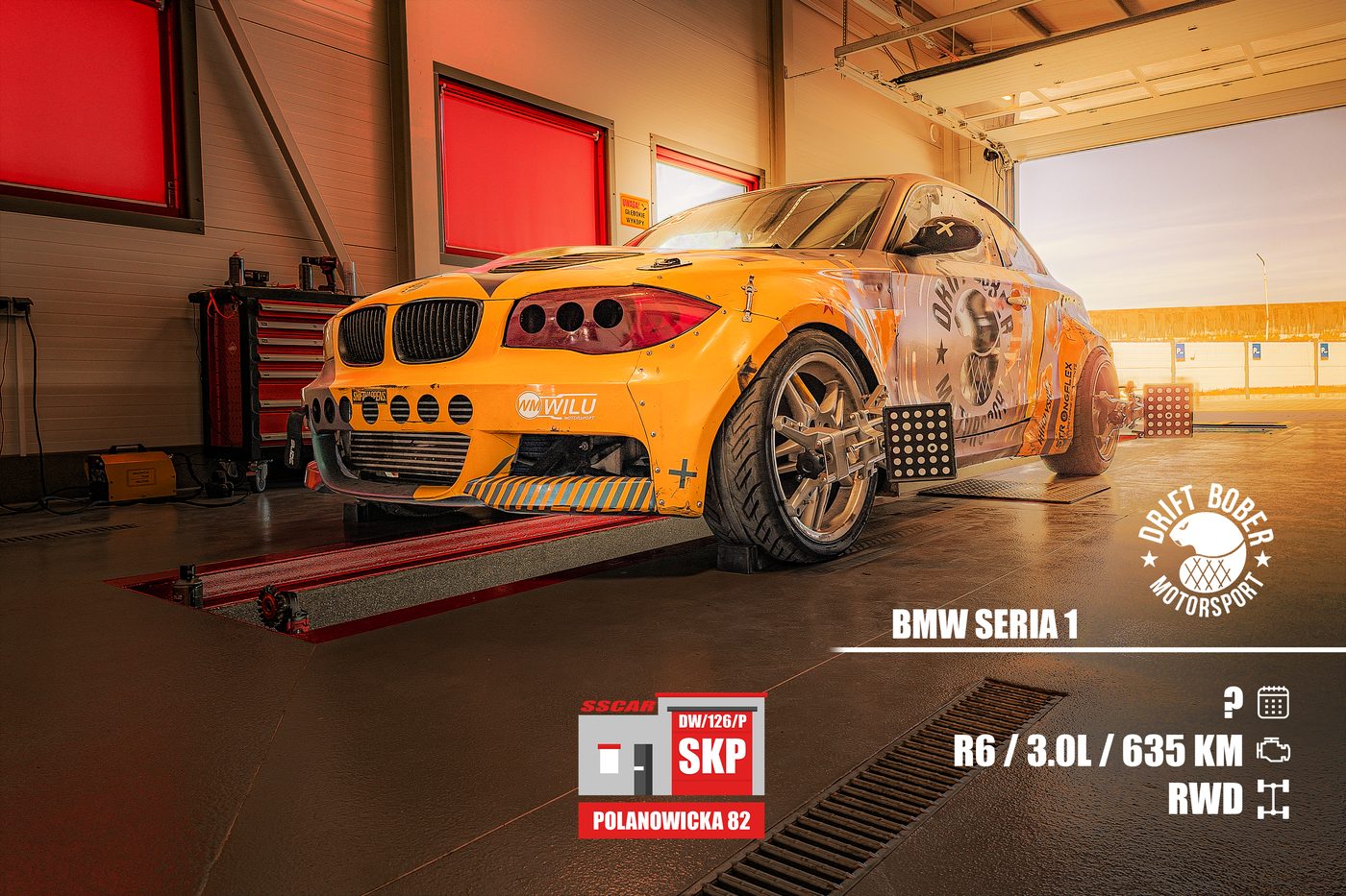 Pomarańczowe BMW serii 1 zespołu Drift Bober Motorsport na stanowisku geometrii 3D, z tarczami pomiarowymi przypiętymi do kół